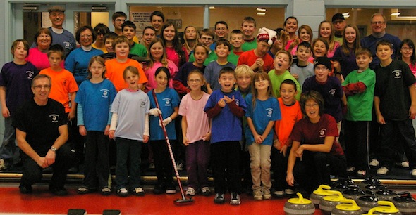 Darryl Horne, kneeling front left, and his wife Kate, kneeling, right, are constantly working with young curlers to get them hooked on the Roaring Game. (Photo, courtesy Darryl Horne)