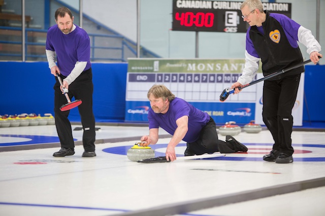 Yukon's Doug Hamilton delivers his rock with sweepers Dale Enzenauer and Doug Gee in Draw 3 action at the 2014 Canadian Senior Curling Championships in Yellowknife (Photo James MacKenzie)
