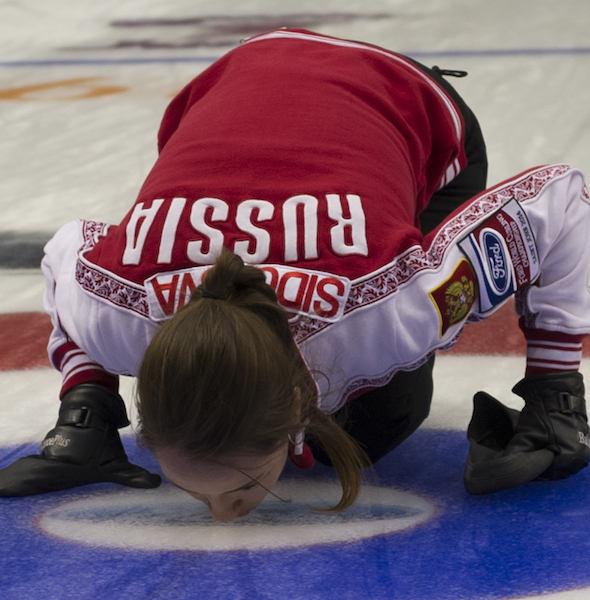 Russian skip Anna Sidorova kisses the ice after her team's bronze-medal victory on Sunday. (Photo, CCA/Michael Burns)