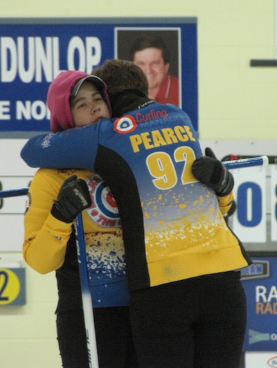After 40 hours of continuous curling Amanda Pearce (facing camera) gets an encouraging hug from her twin sister Brittany. The 22-year-olds are the only women in Canada to have beaten two world records for the longest curling game (Photo Clarissa Yahn)
