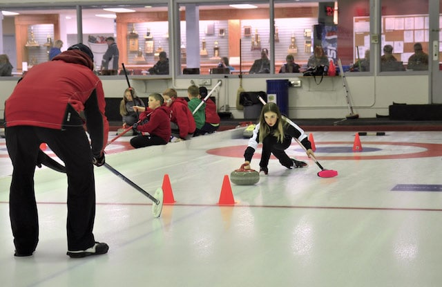 A young Elmwood CC curler gets some one-on-one instruction on her delivery in the thriving youth program (Photo courtesy B. Quesnel)