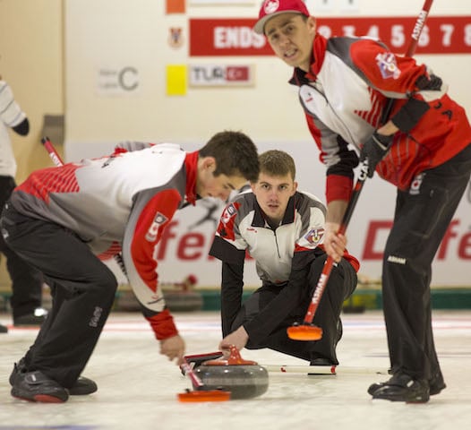 Team Canada alternate Wade Ford throws his rock to sweepers Colton Lott and Kyle Doering at the 2016 World Junior Curling Championship (WCF/Marissa Tiel photo)