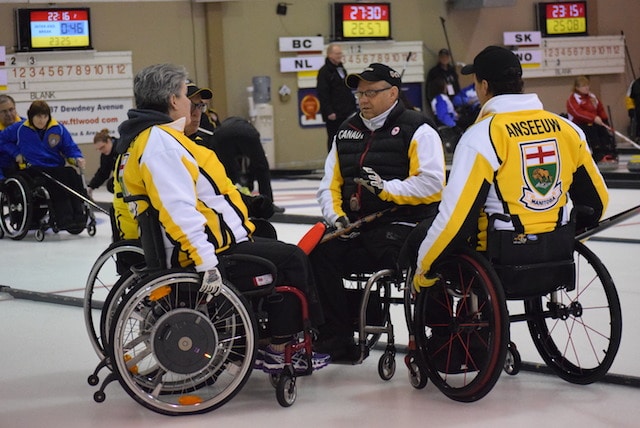 Team Manitoba listens to skip Mark Thiessen during a huddle on the ice at the 2016 Canadian Wheelchair Championship in Regina (Curling Canada/Morgan Daw photo)