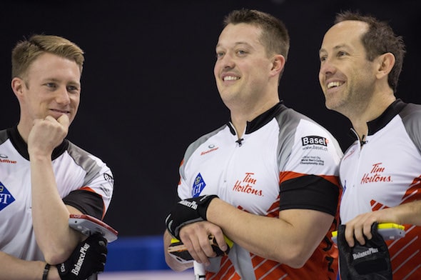 From left, Team Canada's Marc Kennedy, Ben Hebert and Brent Laing take a break from the pressure of Friday night's game. (Photo, World Curling Federation/Céline Stucki)
