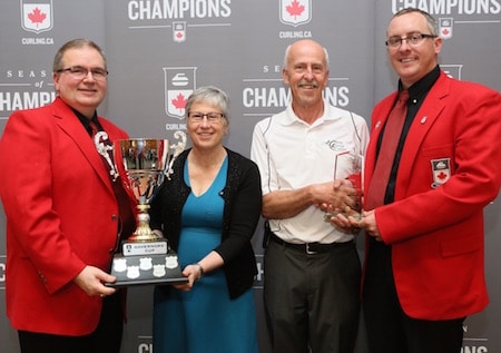 Nova Scotia won the Governors' Cup. Governors Hugh Avery, left, and Scott Comfort, right, present the Governors' Cup to Cathy Dalziel and Harry Daemen of the Nova Scotia Curling Association. (Photo, Curling Canada/Neil Valois)