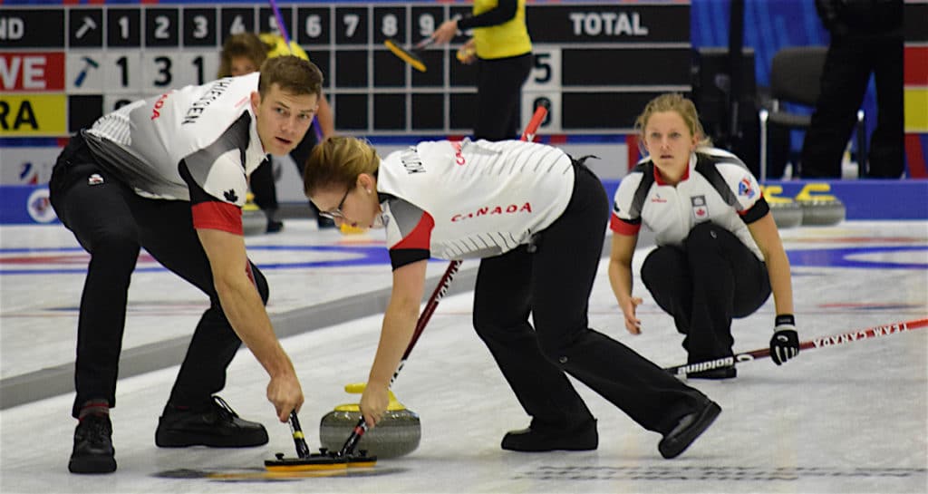 Canada's Brad Thiessen and Alison Kotylak sweep for Sarah Wilkes at the Kazan Sports Palace during action at the 2016 World Mixed Curling Championship (Photo World Curling Federation/Alina Androsova)
