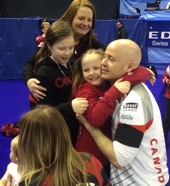 Kevin Koe shares a moment of celebration with wife, Carla, and their two daughters after winning the gold medal at the 2016 World Men’s Curling Championship in Basel, Switzerland (Curling Canada photo)