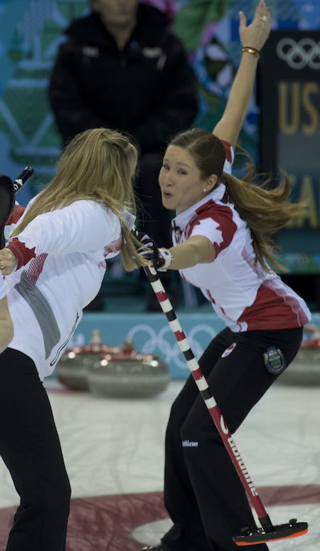 No, they're not dancing! Team Canada's Jennifer Jones, left, and Kaitlyn Lawes stumble as they exchange brooms during Sunday's win over the U.S. (Photo, CCA/Michael Burns)