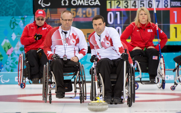 Sochi, RUSSIA - Mar 10 2014 -  Dennis Thiessen looks on as Mark Ideson takes a shot  during Canada vs USA in Wheelchair Curling round robin play at the 2014 Paralympic Winter Games in Sochi, Russia.  (Photo: Matthew Murnaghan/Canadian Paralympic Committee)