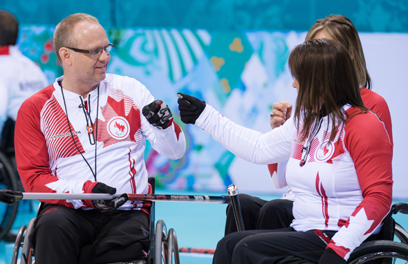 Sochi, RUSSIA - Mar 11 2014 -  Dennis Thiessen and Ina Forrest fist bump as Canada takes on China in Wheelchair Curling at the 2014 Paralympic Winter Games in Sochi, Russia.  (Photo: Matthew Murnaghan/Canadian Paralympic Committee)