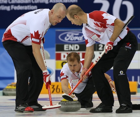 Team Canada sweepers Nolan Thiessen, left, and Pat Simmons go to work on Carter Rycroft's rock. Kevin Koe's Canadian posted a huge win over Germany on Thursday morning. (Photo, World Curling Federation/Richard Gray)