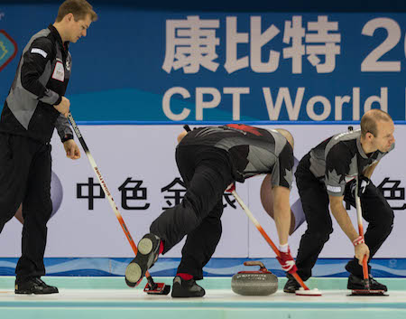 Team Canada's Carter Rycroft, left, supervises the sweeping efforts of Nolan Thiessen, middle, and Pat Simmons. (Photo, World Curling Federation / Céline Stucki)