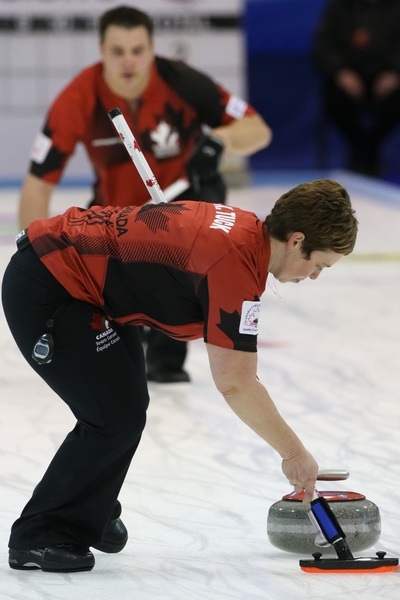 Team Canada’s Kim Tuck sweeps as Wayne Tuck delivers his rock at the 2014 World Mixed Doubles Curling Championship in Dumfries, Scotland (Photo WCF/Richard Gray)